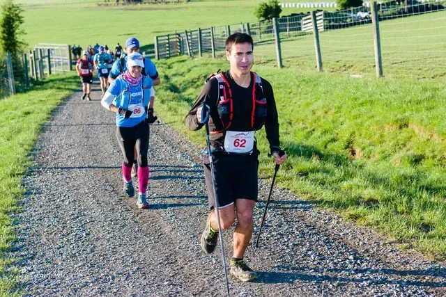 A group of people are running down a dirt road.