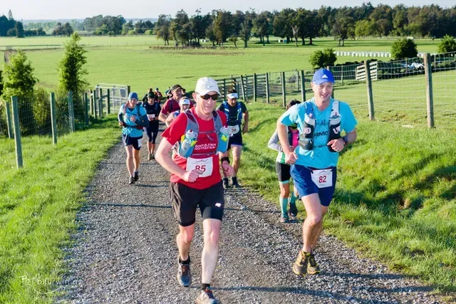A group of people are running down a dirt road.