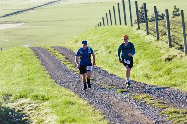Two men are running down a dirt road.