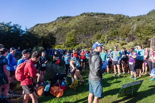 A group of people are standing in a grassy field.