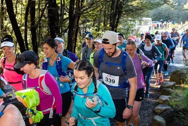 A group of people are walking down a path in the woods.