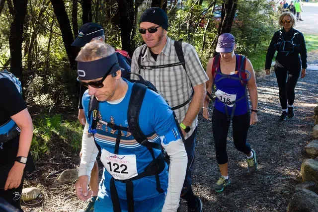 A man with the number 122 on his shirt is walking with a group of people.
