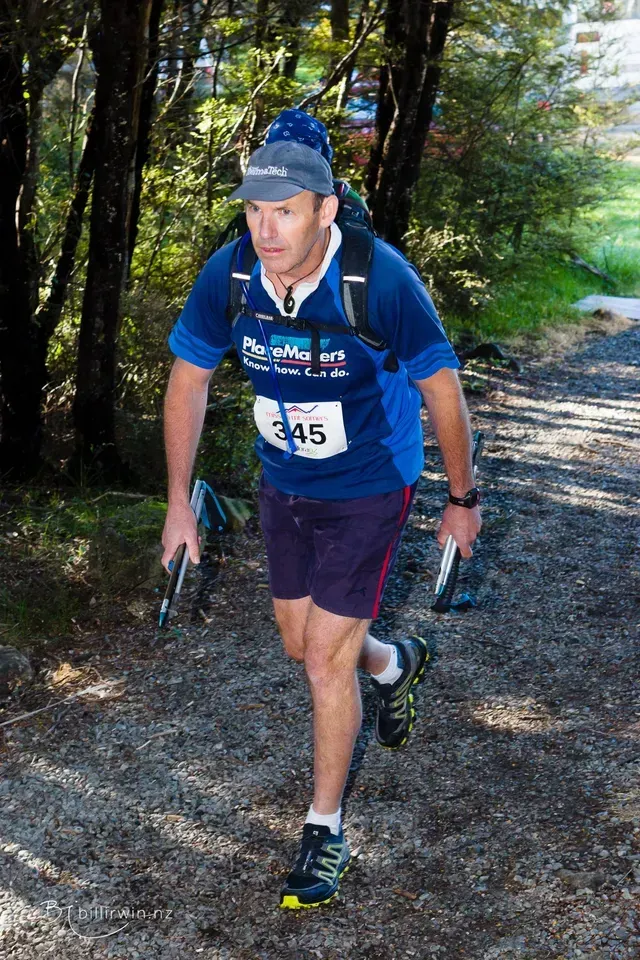 A man wearing a number 45 shirt is running down a trail.