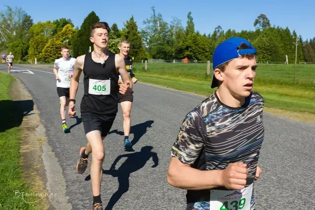 A group of young men are running down a road.