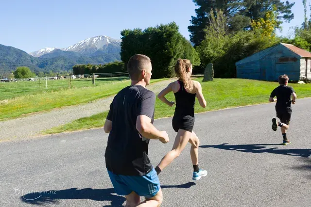 A group of people are running down a road.