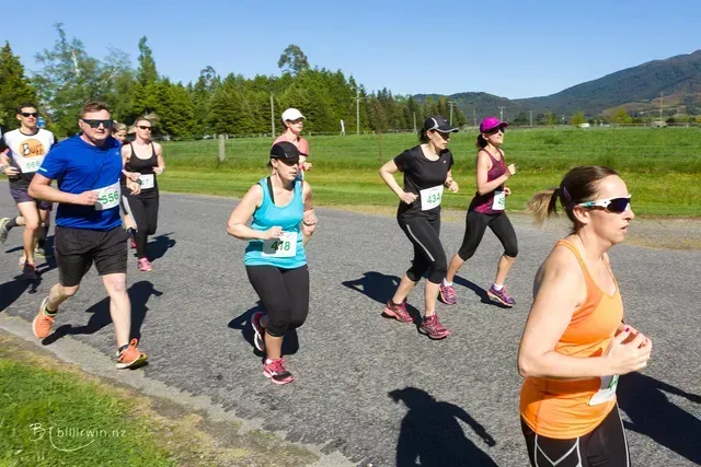 A group of people are running down a road.