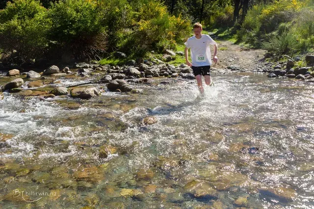 A man is running through a stream of water.