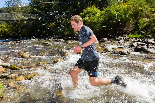 A man is running through a stream of water.