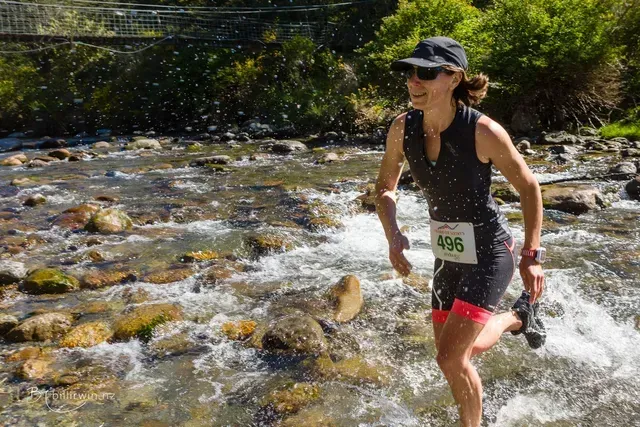 A woman is running through a stream of water.