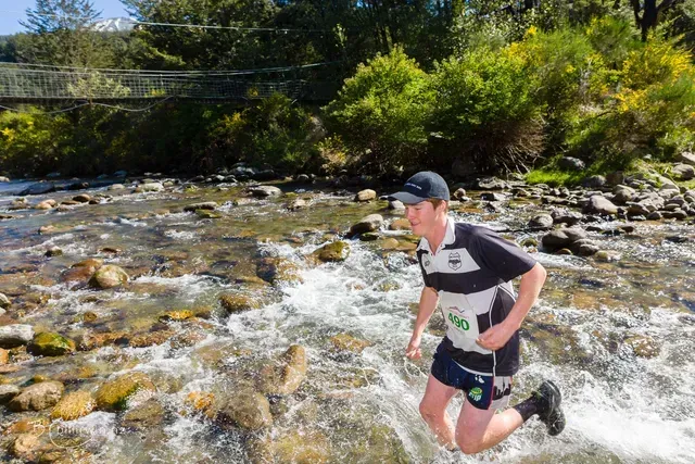 A man is running through a stream of water.