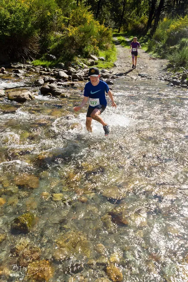 A person is running through a stream of water.