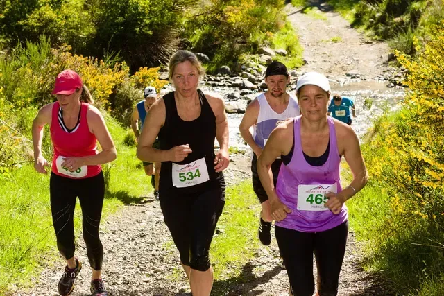 A group of women are running down a dirt path.