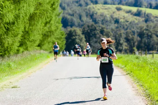 A woman is running down a road in a marathon.