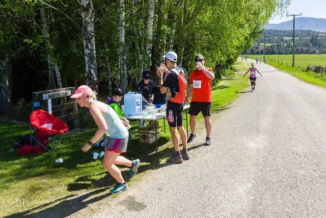 A group of people are standing around a table on the side of a road.