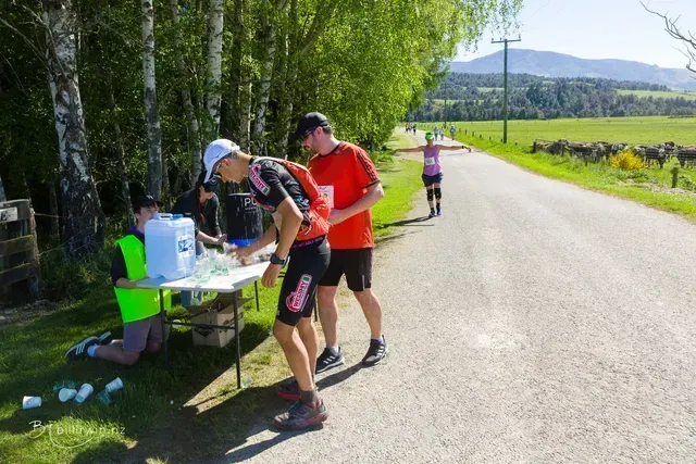 A group of people are standing around a table on the side of a road.