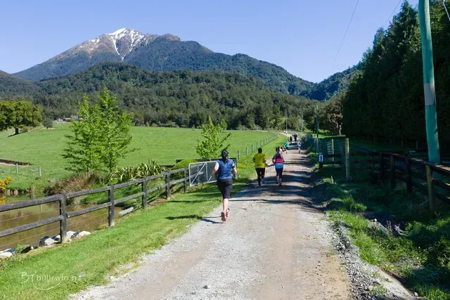 A group of people are running down a dirt road.