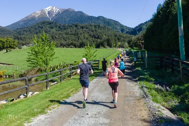 A group of people are running down a dirt road.