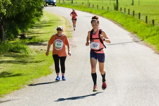 A group of women are running down a road.