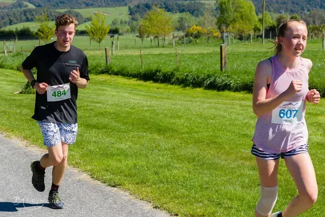 A man and a woman are running a race on a road.