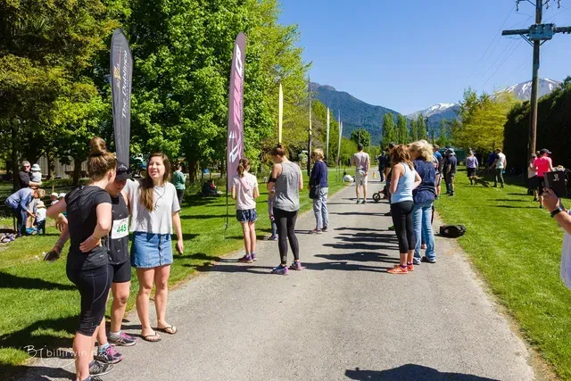 A group of people are standing on the side of a road.