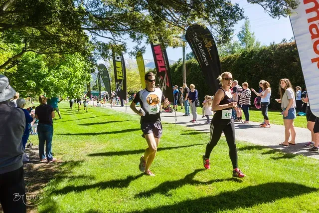 A man and a woman are running in a park.