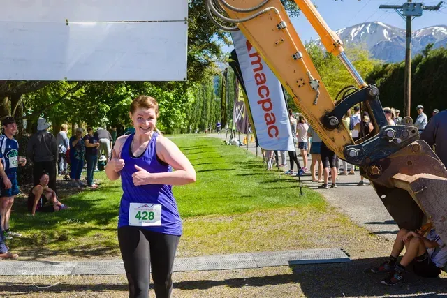 A woman wearing a purple tank top with the number 428 on it