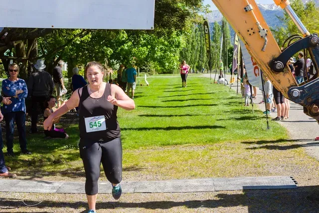 A woman is running in a race with a number on her shirt.