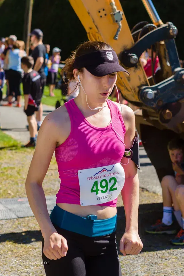 A woman is running in a race with a tag that says 492