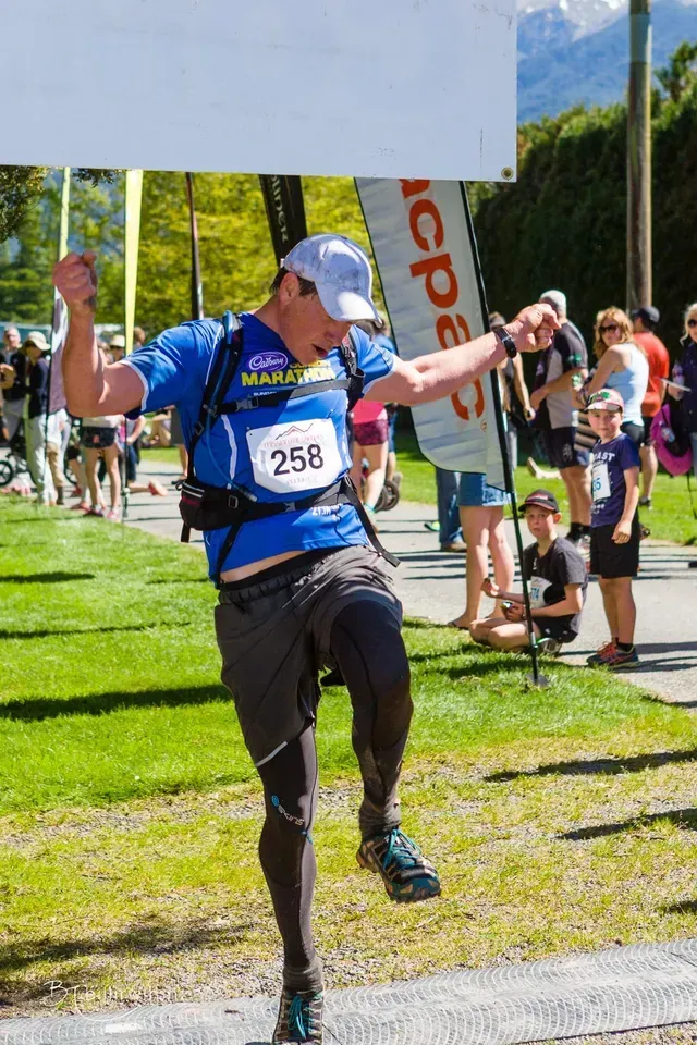 A man wearing a blue shirt with the number 258 on it is running a race.