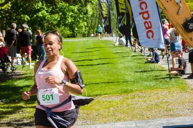 A woman is running in a race with the number 501 on her shirt.