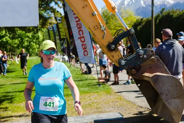 A woman is running in a race with the number 441 on her shirt