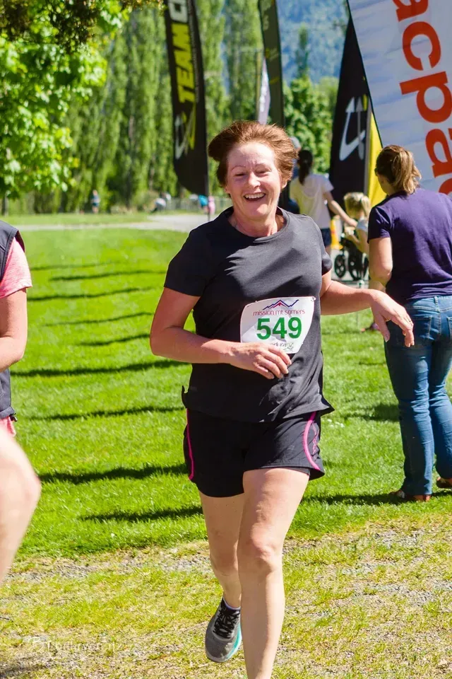 A woman is running in a race with the number 549 on her shirt.
