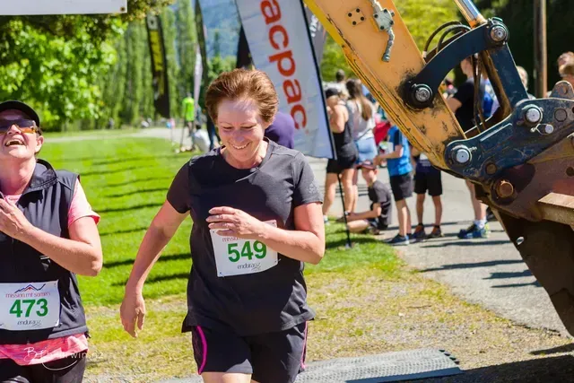 Two women are running in a race and one has the number 549 on her shirt.