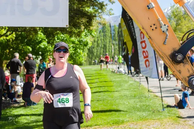 A woman is running in a race with the number 468 on her shirt.