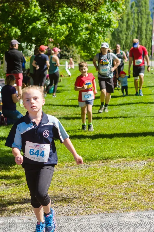 A group of people are running a race in a park.