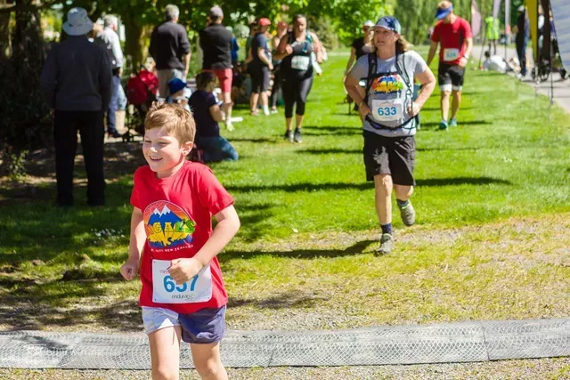 A group of people are running a race in a park.