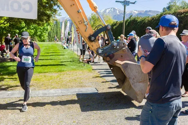 A man is taking a picture of a woman running in a race