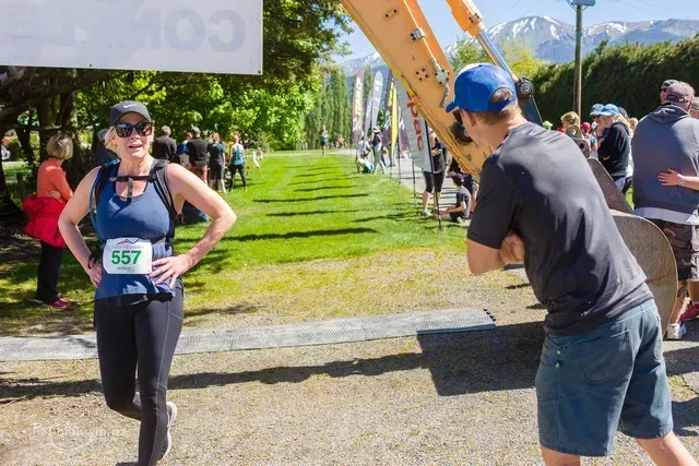 A man is taking a picture of a woman running in a race.