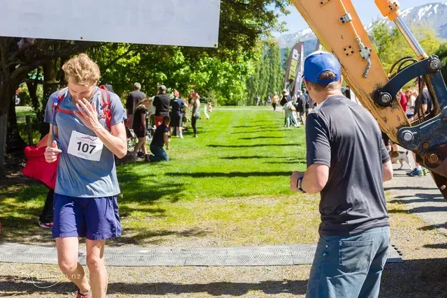 A man wearing a number 107 shirt is running in a park.