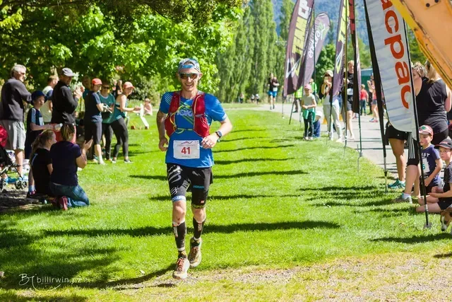 A man is running in a race with a number 21 on his shirt.