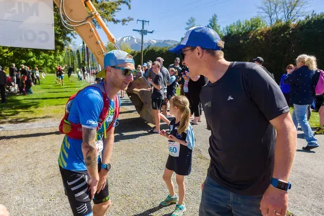 A man and a little girl are talking to each other on a street.
