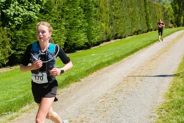 A woman is running down a dirt road.