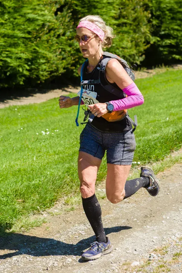 A woman is running down a dirt road.