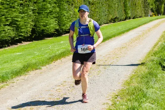 A woman is running down a dirt road.