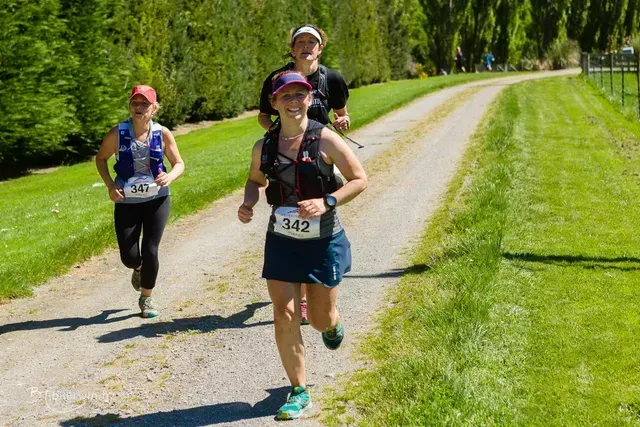A group of people are running down a dirt road.