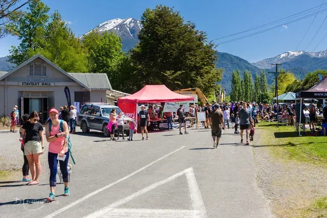 A group of people are walking down a street in front of a building.