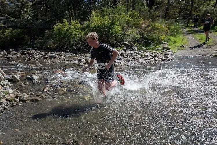 A person is running through a stream of water.