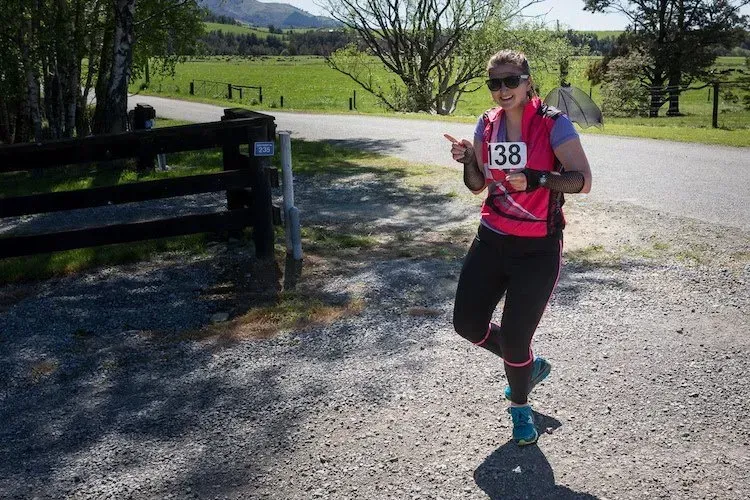 A woman is running down a dirt road.