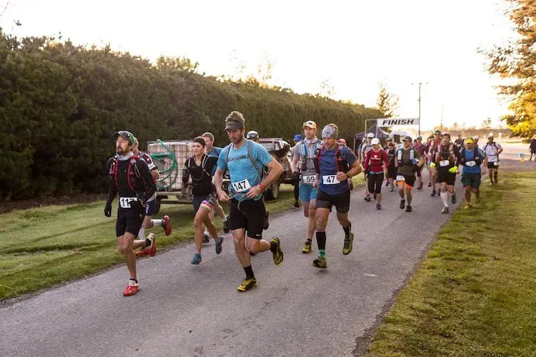 A group of people are running down a road.