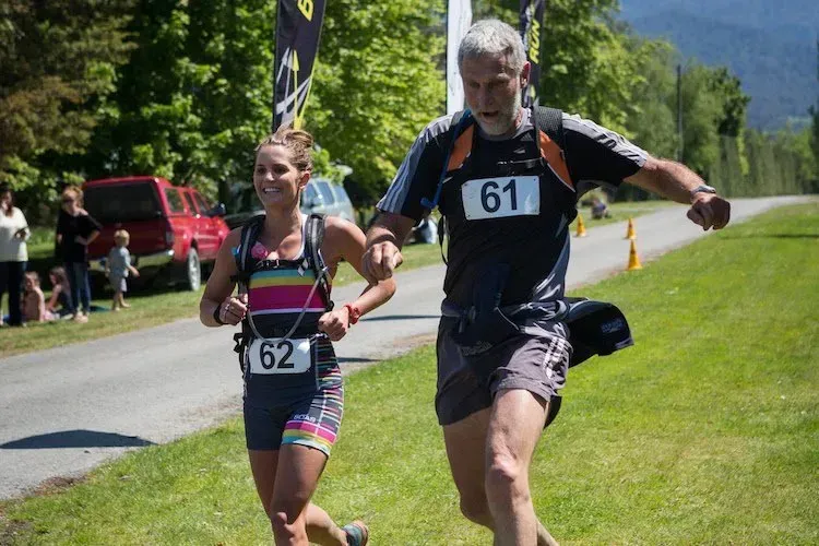 A man and a woman are running down a road.
